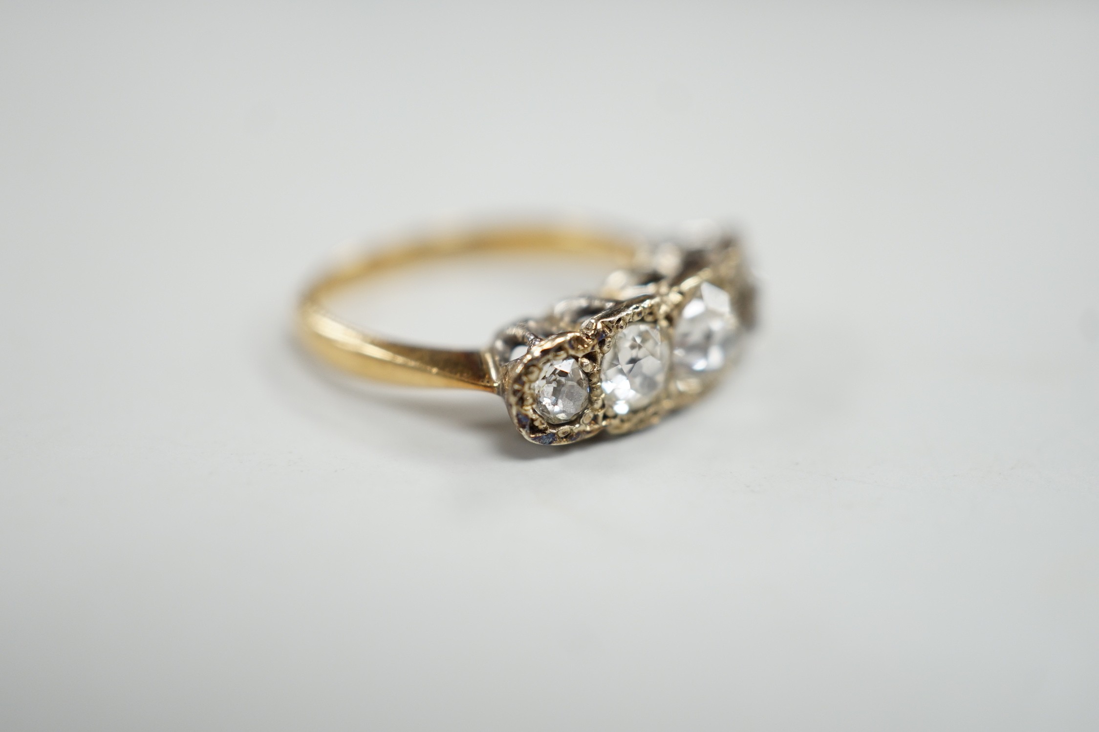 An 18ct, plat and graduated five stone diamond set half hoop ring, size J/K, gross weight 3.3 grams.
